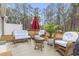 Outdoor patio setting with wicker furniture, a red umbrella and a view of the lush backyard at 101 Galil Dr. # A, Myrtle Beach, SC 29579