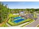 Aerial view of community tennis courts, pool, clubhouse, and surrounding greenery at 1145 Windy Grove Ln Sw # 16, Ocean Isle Beach, NC 28469