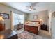 Cozy bedroom with a ceiling fan, plush carpeting, a large window with natural light, and warm, neutral wall color at 1182 Palm Crossing Dr., Little River, SC 29566