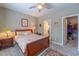 Comfortable bedroom featuring a ceiling fan, neutral walls, a wooden bed frame, bedside table, and an open doorway to closet at 1182 Palm Crossing Dr., Little River, SC 29566