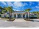 The community clubhouse features a neutral palette, grand entrance, and is surrounded by palm trees at 1182 Palm Crossing Dr., Little River, SC 29566