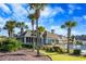 The back of the community clubhouse features views of the pool and lounge chairs and is surrounded by palm trees at 1182 Palm Crossing Dr., Little River, SC 29566