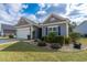 Charming single-story home with gray siding, attached garage, and well-manicured landscaping at 1182 Palm Crossing Dr., Little River, SC 29566