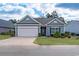 Charming single-story home with a two-car garage and well-manicured lawn at 1182 Palm Crossing Dr., Little River, SC 29566
