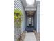 Covered entrance to a home with gray siding and a decorative trellised plant at 1182 Palm Crossing Dr., Little River, SC 29566