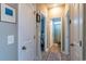 Hallway with neutral-colored walls and light-colored flooring, showcasing doors leading to a bedroom and bathroom at 1182 Palm Crossing Dr., Little River, SC 29566