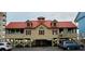 Exterior of an elevated coastal building, featuring a red roof and ample parking at 1221 Tidewater Dr. # 2821, North Myrtle Beach, SC 29582