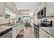 Modern kitchen with stainless steel appliances and granite counters overlooks the dining area at 133 Puffin Dr. # 3-E, Pawleys Island, SC 29585