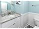 Stylish bathroom with granite vanity top, wainscoting, and blue wall paint at 1411-A N Ocean Blvd., Surfside Beach, SC 29575