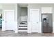 Bright hallway features stairs, white trim and doors, and stainless steel refrigerator at 1411-A N Ocean Blvd., Surfside Beach, SC 29575