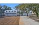 Back exterior of home and garages framed by lush trees and a driveway leading up to them at 161 Twelve Oaks Dr., Pawleys Island, SC 29585