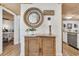 Hallway showcasing a decorative mirror, rustic cabinet, and views into the kitchen at 163 Heron Marsh Dr. # 61, Pawleys Island, SC 29585