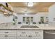 A close-up of the kitchen island sink and granite countertops overlooking the dining area with modern chandelier at 163 Heron Marsh Dr. # 61, Pawleys Island, SC 29585