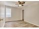 A simple bedroom with neutral walls, ceiling fan, window, and light-toned wood-look floors at 1741 Rice St., Georgetown, SC 29440