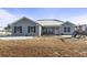 Charming one-story home with gray siding, black shutters and front yard with sparse grass and some snow at 1801 Heirloom Dr., Conway, SC 29527