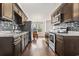 Well-lit kitchen with stainless steel appliances, dark wood cabinets, and a view of the adjacent dining area at 1801 Heirloom Dr., Conway, SC 29527