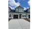 A new construction townhome exterior featuring light green siding, black roof, and an attached garage at 1989 Wild Indigo Circle Nw # 9, Calabash, NC 28467