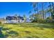 Expansive backyard with lush green grass and mature trees in the background at 221 Hagley Dr., Pawleys Island, SC 29585