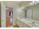 Bathroom with dual sinks and large mirror, with an open door view into a bedroom at 221 Hagley Dr., Pawleys Island, SC 29585