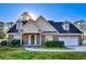 Charming, red brick two-story home featuring dormer windows, a two-car garage, and well-maintained landscaping at 221 Hagley Dr., Pawleys Island, SC 29585