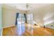 Bright living room with wood floors, ceiling fan, sliding glass doors, and an additional sunroom adjacent to the room at 221 Hagley Dr., Pawleys Island, SC 29585