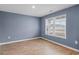 Serene bedroom with blue walls and wood-look flooring offers a bright window with natural light and outlets at 224 Pine Forest Dr., Conway, SC 29526