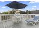 Deck features a large umbrella covered table, seating for four, and a cushioned chaise lounge at 300 Oak Lake Circle, North Myrtle Beach, SC 29582