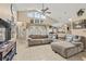 Bright living room featuring vaulted ceilings, tile floors, large windows, and an oversized comfortable couch at 3103 Robyn Ct., Little River, SC 29566