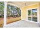 Covered porch with white columns and concrete flooring next to grassy backyard at 3127 Tiger Tail Rd., Conway, SC 29526