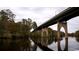 An over the water view of a long vehicle bridge in an area with lush green trees and foliage at 3127 Tiger Tail Rd., Conway, SC 29526