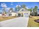 Attractive single-Gathering home with bright yellow siding, stone accents, and a pristine concrete driveway at 3127 Tiger Tail Rd., Conway, SC 29526