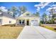 Charming yellow home with a well-manicured lawn, a one-car garage, and stone accents on the front facade at 3127 Tiger Tail Rd., Conway, SC 29526