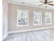 Sunlit living room with wood grain floors, featuring large windows overlooking trees at 3127 Tiger Tail Rd., Conway, SC 29526