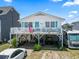 Charming raised beach house with white siding, an American flag, and a spacious front deck at 315 60Th Ave. N, North Myrtle Beach, SC 29582