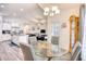 Open-concept dining room featuring a glass table, neutral chairs, and a view of the kitchen and living room at 321 Rycola Circle, Surfside Beach, SC 29575