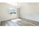 Light-filled dining area with modern chandelier, wood floors, and a scenic backyard view at 3321 Little Bay Dr., Conway, SC 29526