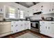 Well-lit kitchen features white cabinetry, modern appliances, and hardwood floors at 342 Dogwood Dr. S, Murrells Inlet, SC 29576