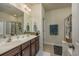 Bright bathroom featuring a double sink vanity, framed mirror, and a glass-enclosed shower at 3507 Club Course Dr., North Myrtle Beach, SC 29582