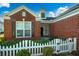 Charming brick home featuring a white picket fence and well-maintained landscaping at 3507 Club Course Dr., North Myrtle Beach, SC 29582