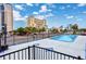 Outdoor community pool with a view of nearby buildings and palm trees on a sunny day at 400 20Th Ave. N # 101, Myrtle Beach, SC 29577