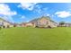 Wide view of backyard featuring manicured lawn, home exterior, and mature trees at 401 Oak Crest Circle, Longs, SC 29568