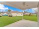 View from covered patio of large, manicured backyard with lush grass and palm trees at 401 Oak Crest Circle, Longs, SC 29568