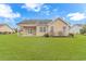 Back exterior view of the house with well-maintained lawn and covered patio at 401 Oak Crest Circle, Longs, SC 29568