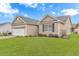 Exterior home showcasing a well-maintained lawn and partial view of the two-car garage at 401 Oak Crest Circle, Longs, SC 29568