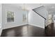 Bright dining room with elegant chandelier, dark hardwood floors, white trim, and staircase access at 425 Retriever Ct., Murrells Inlet, SC 29576