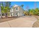 Stylish two-story home showcasing an attached two-car garage and spacious concrete driveway surrounded by mature trees at 425 Retriever Ct., Murrells Inlet, SC 29576