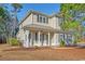 Inviting two-story home featuring a metal roof, black shutters and a charming front porch with white columns at 425 Retriever Ct., Murrells Inlet, SC 29576