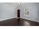 Open living room with dark hardwood floors, chandelier, doorway, and a large window providing natural light at 425 Retriever Ct., Murrells Inlet, SC 29576