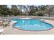 Large community pool surrounded by lounge chairs and lush landscaping at 4413 Bed Straw Ct., Murrells Inlet, SC 29576