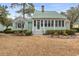 Well-kept home featuring a light green exterior, front porch, and manicured landscaping for curb appeal at 4413 Bed Straw Ct., Murrells Inlet, SC 29576